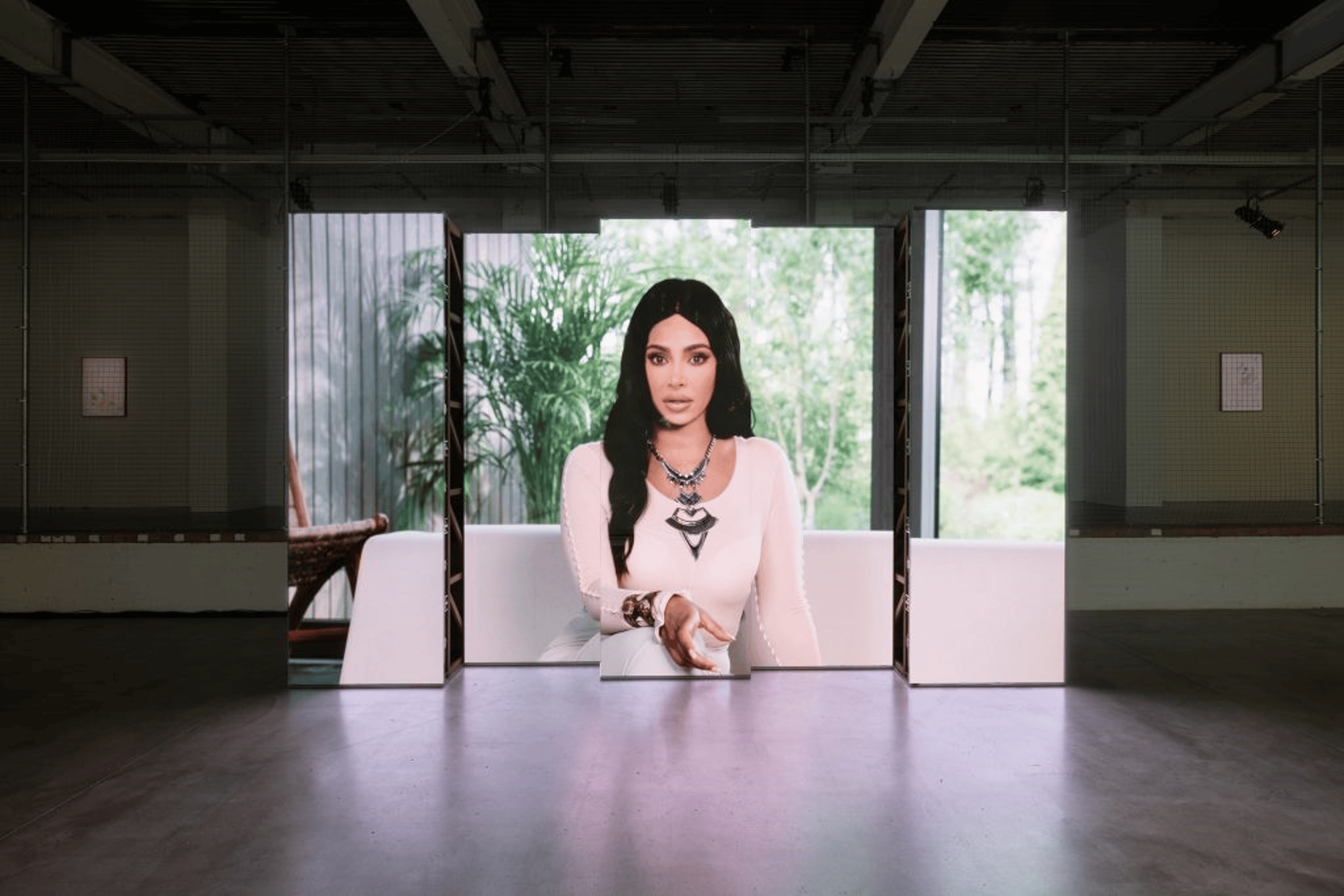A video of Kim Kardashian in a white dress projected into giant cube-shaped mirrors.