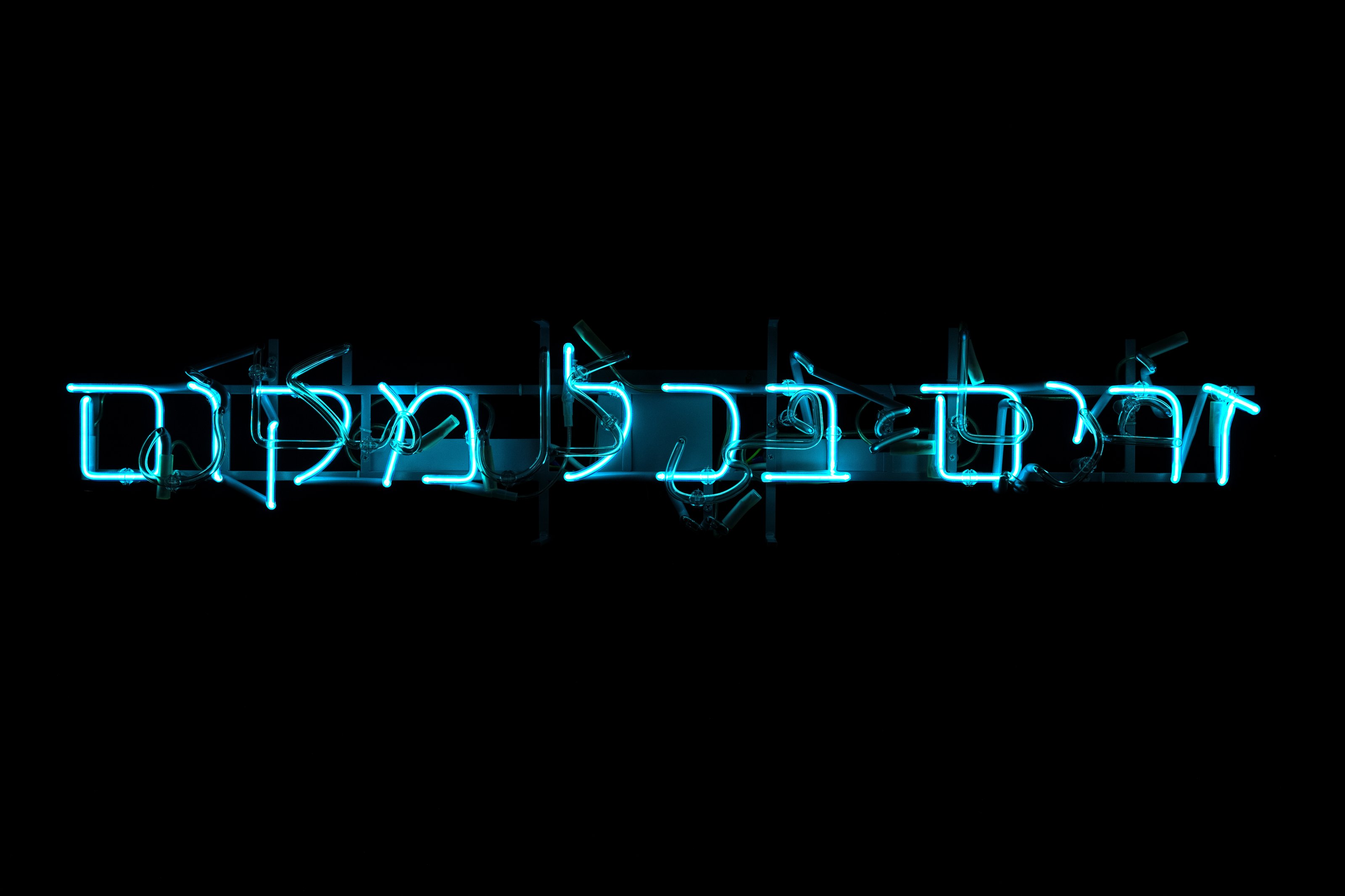 Neon blue text "Foreigners Everywhere" in Hebrew, part of Claire Fontaine's "Foreigners Everywhere, 2010" artwork.