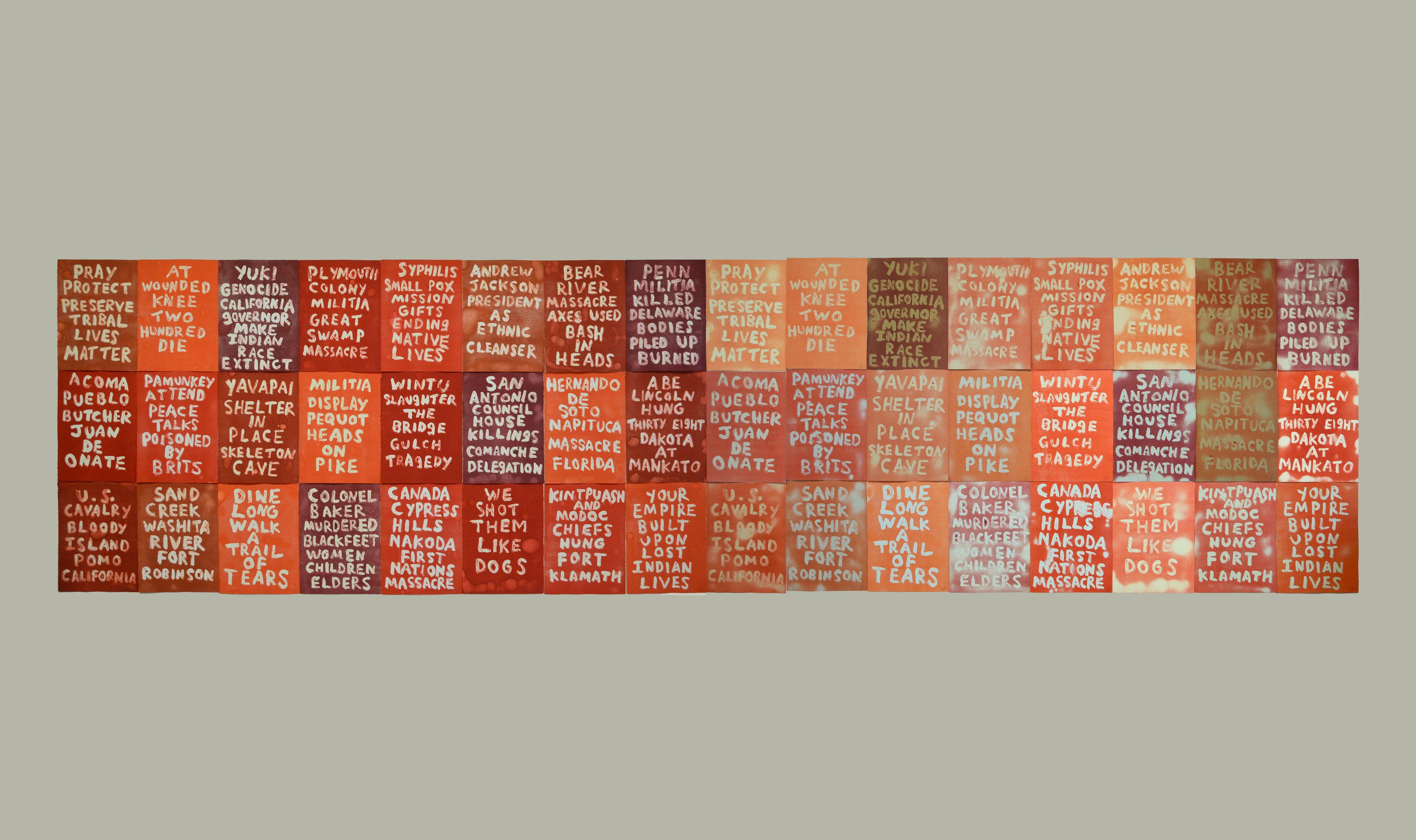 A large artwork composed of multiple tiles with words written in various shades of red and orange, addressing historical injustices against Indigenous peoples.