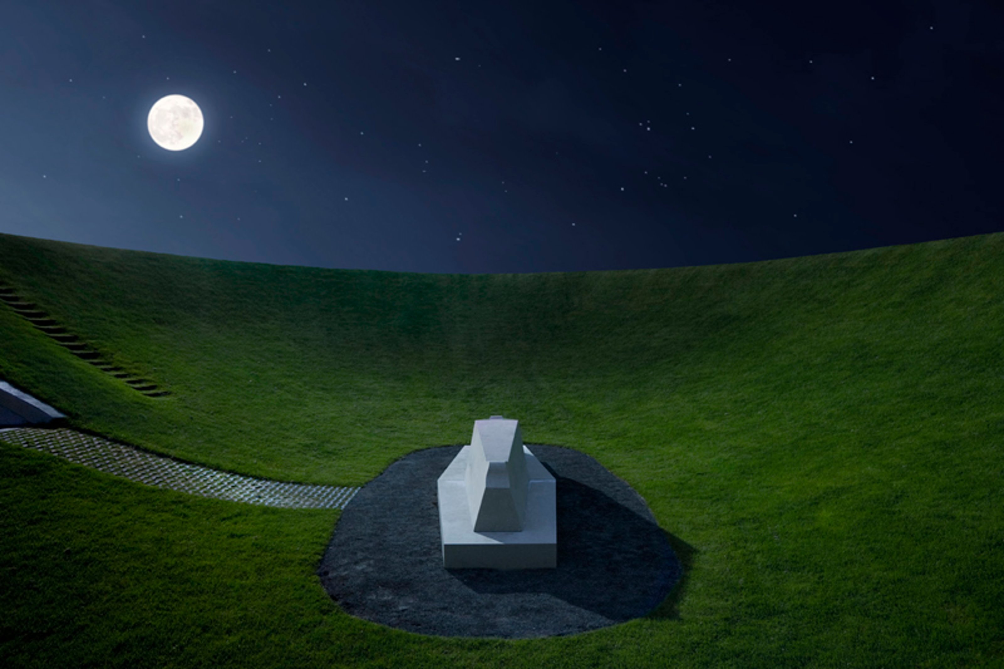 A white cemetery monument surrounded by moonlit grass in the night.