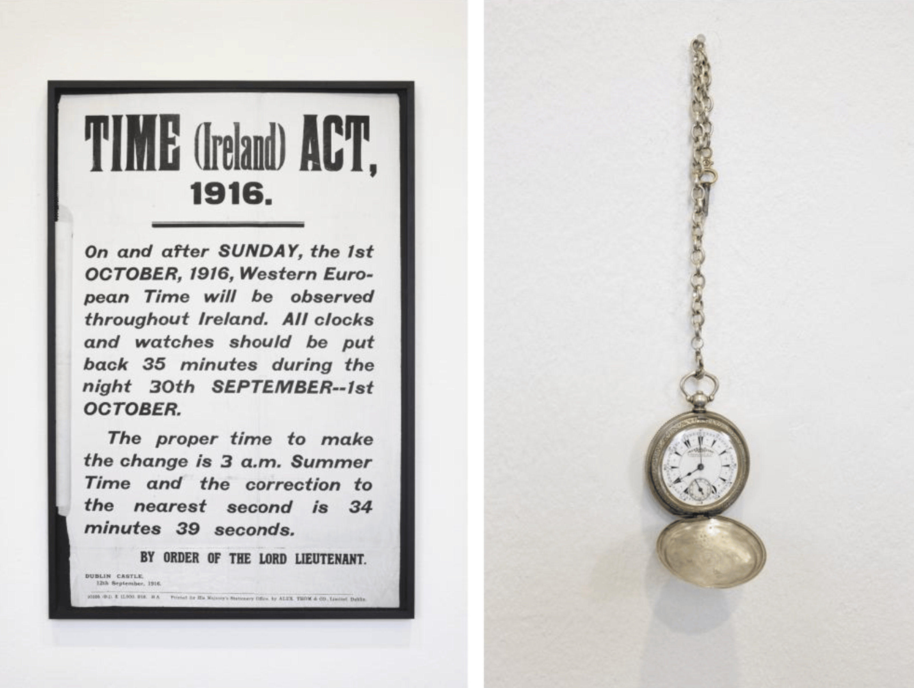 A vintage poster with text detailing the 'Time (Ireland) Act, 1916' and instructions for setting clocks back by 35 minutes. A pocket watch is shown hanging on the right side of the white wall.