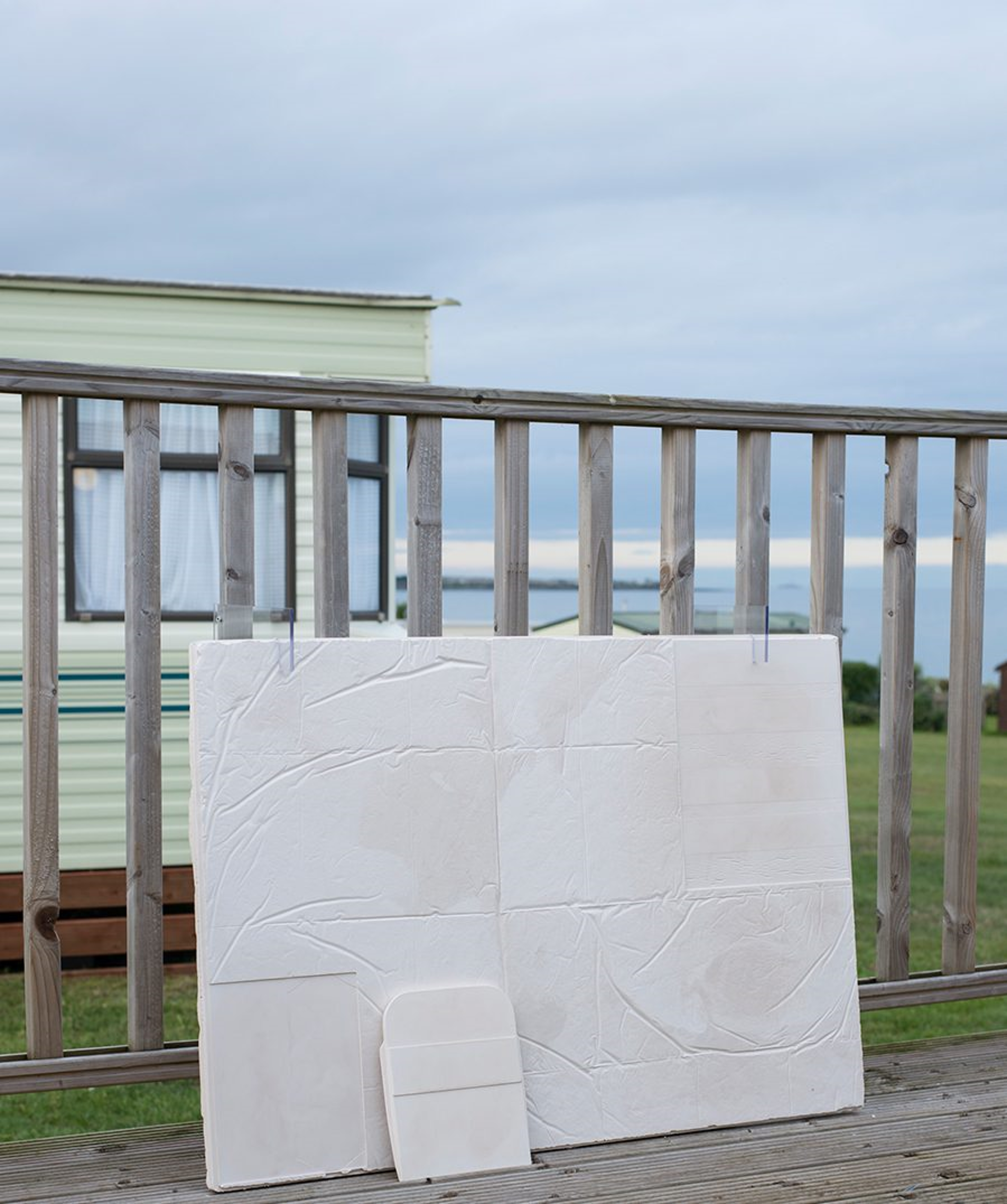 Plaster cast block leaning on a fence