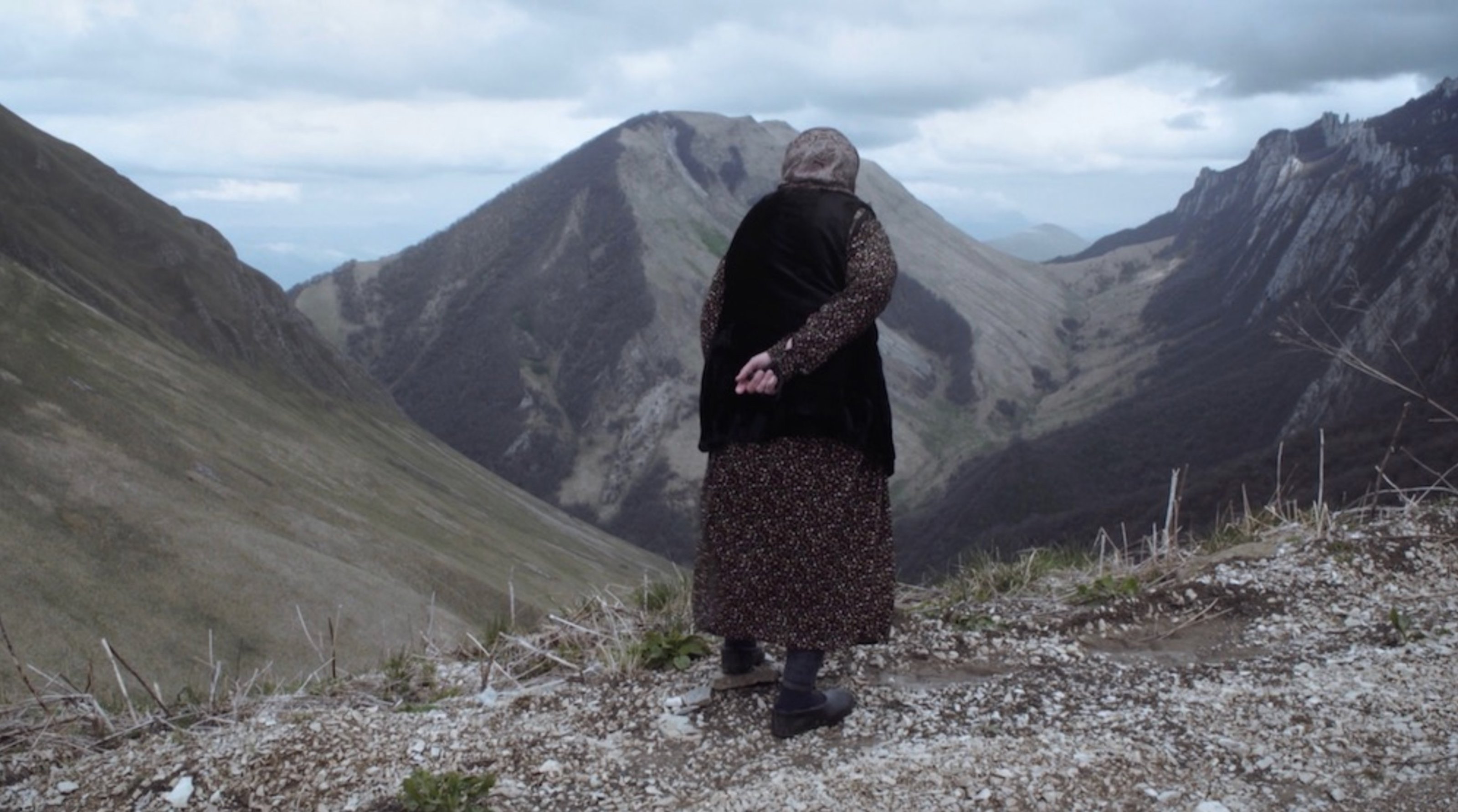 The artist's grandmother stands on a hill in the North Caucasus mountains