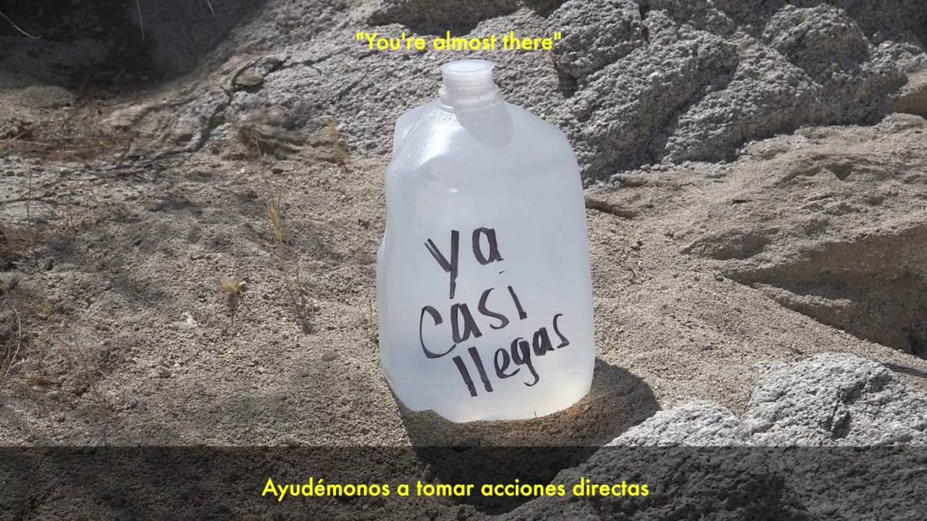 Water bottle on a rock. On the bottle, in handwriting: 