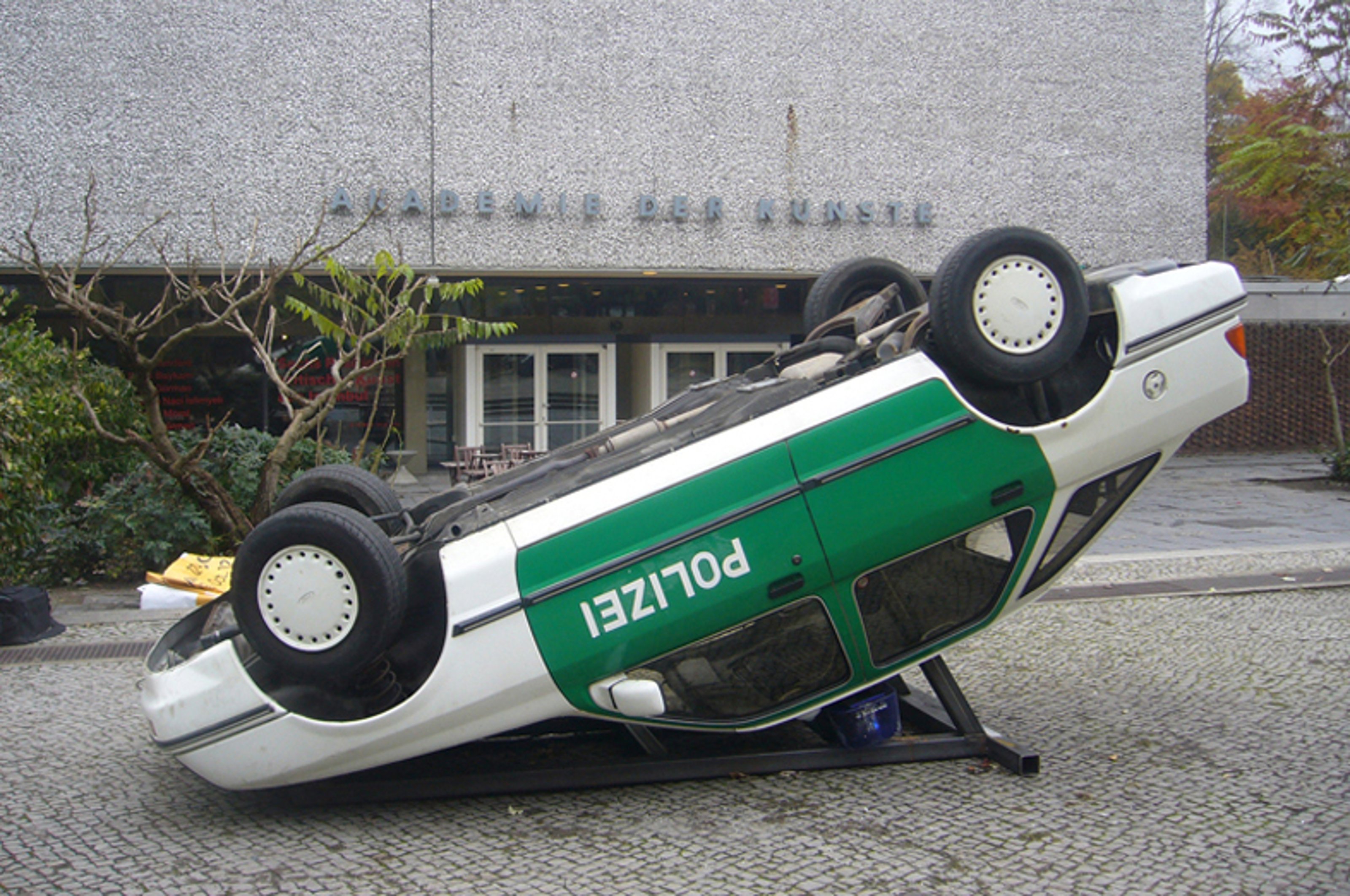 German police car flipped upside down in front of Akademie Der Künst