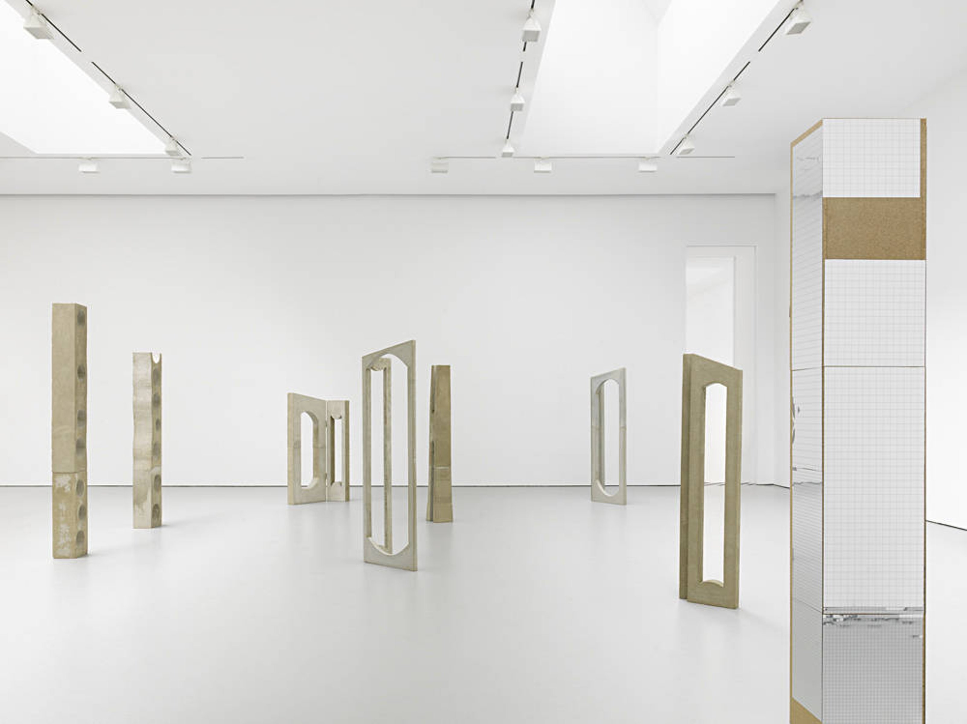 Mirrored reflective column alongside other sculptures by Isa Genzken