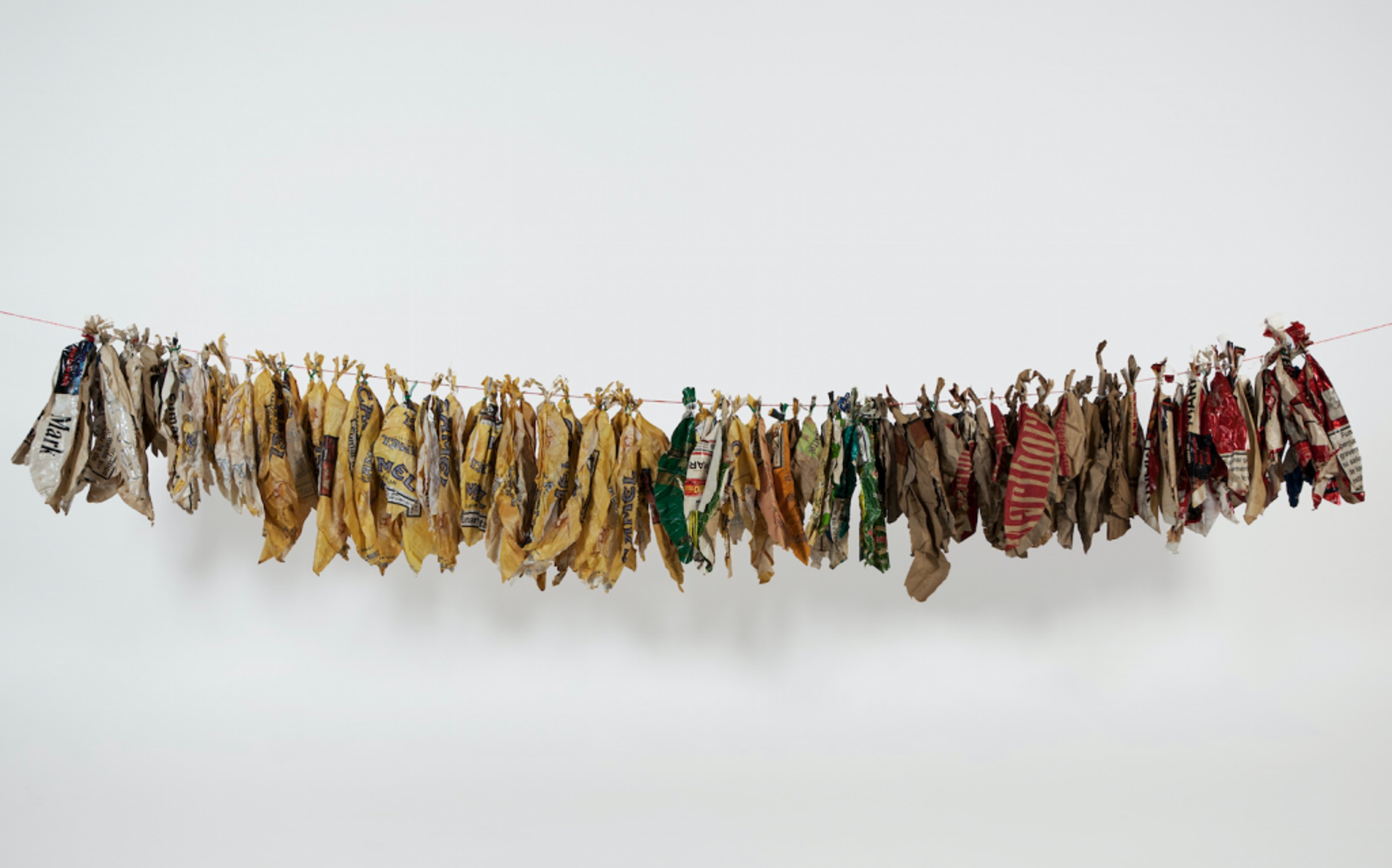 Tobacco packages shaped like leaves, hung in order unto a thread as if leaves are left out to dry