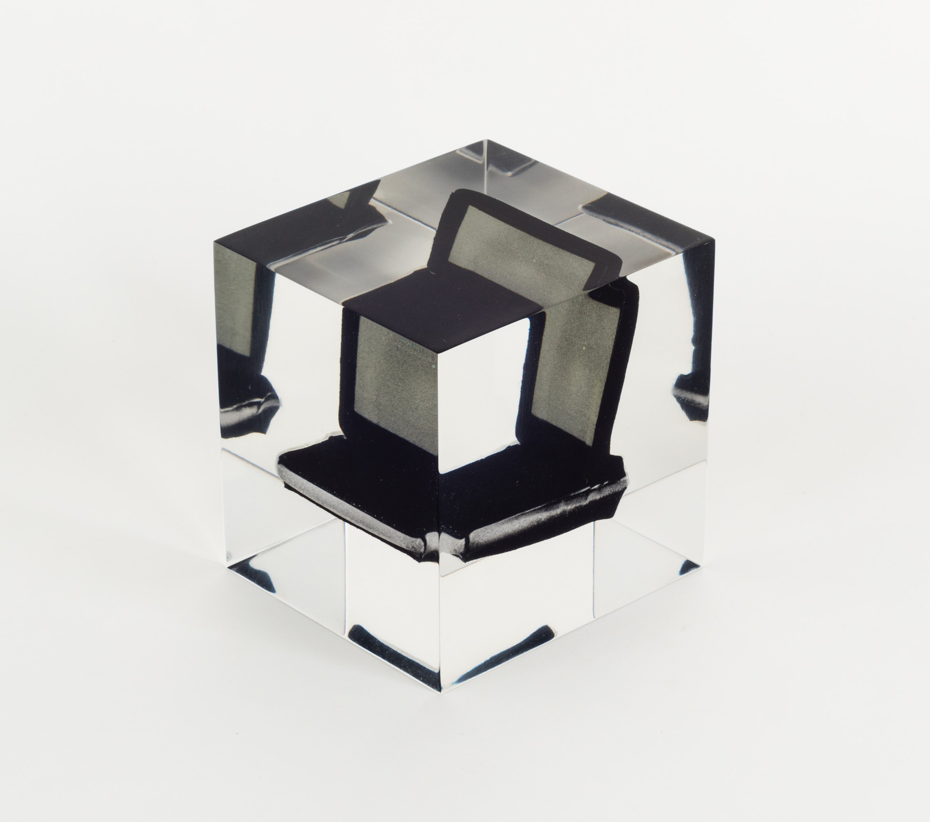 Stress toy shaped as a laptop, embalmed in clear, cubic Lucite (a type of acrylic resin)