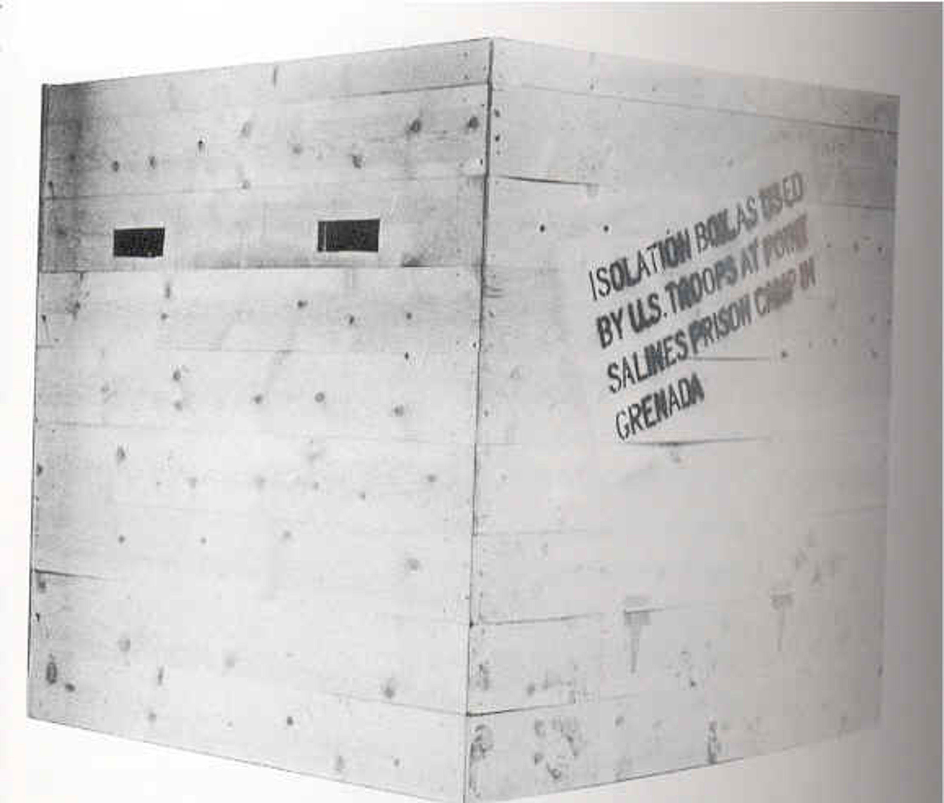 Wooden box with two rectangular holes cut out. Printed on the side of the box: