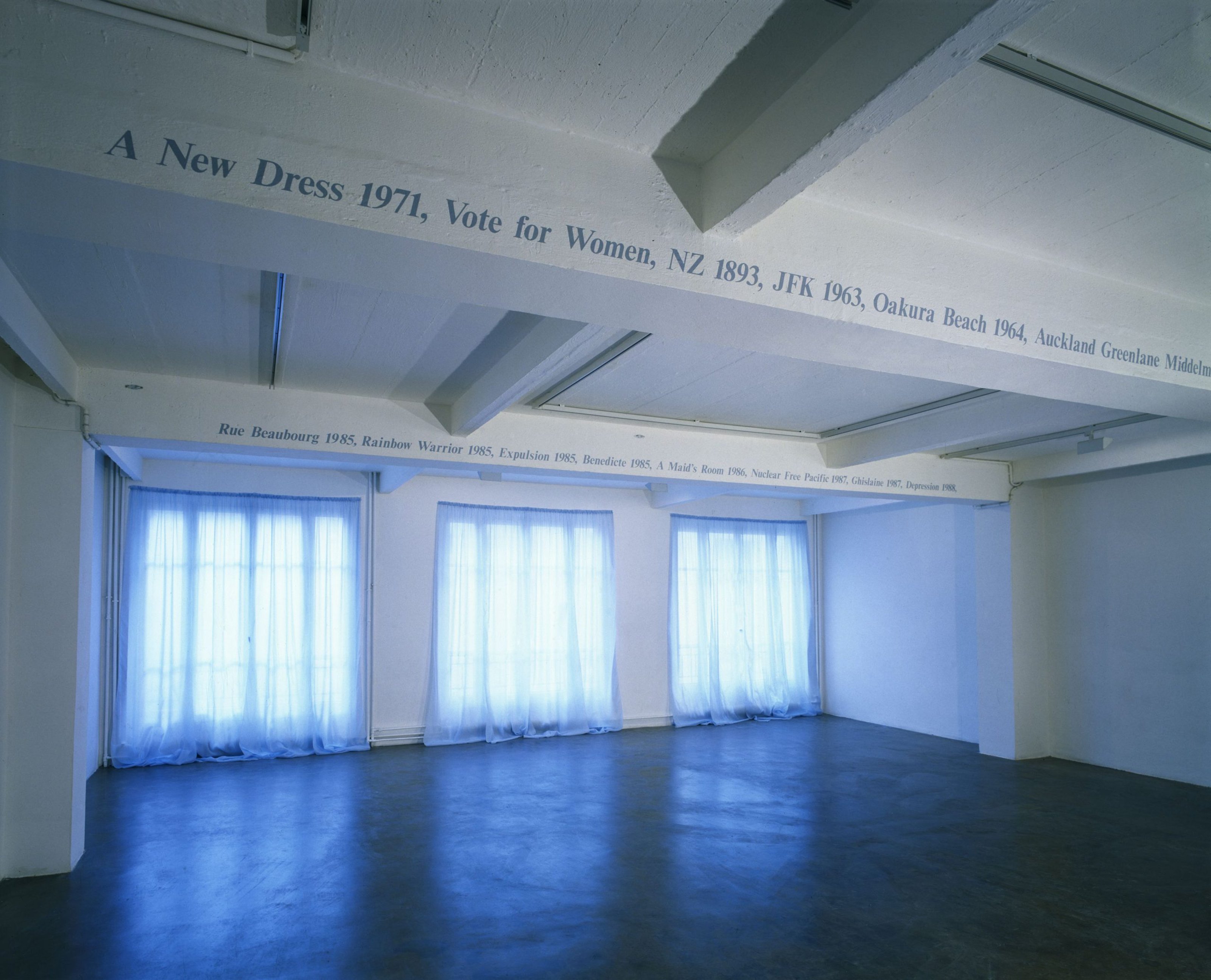 Installation view of black text on a white wall