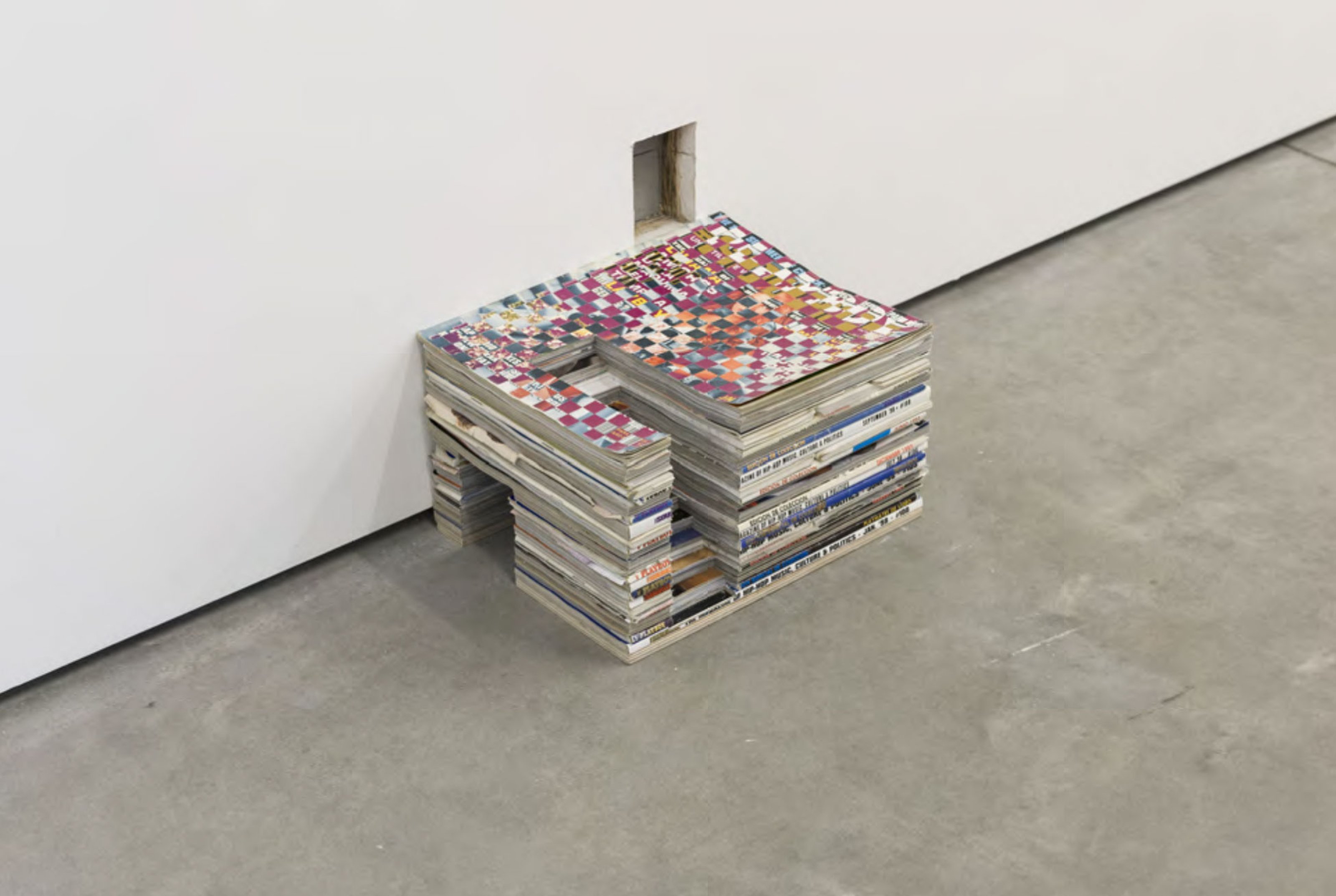 A pile of magazines under a mouse hole