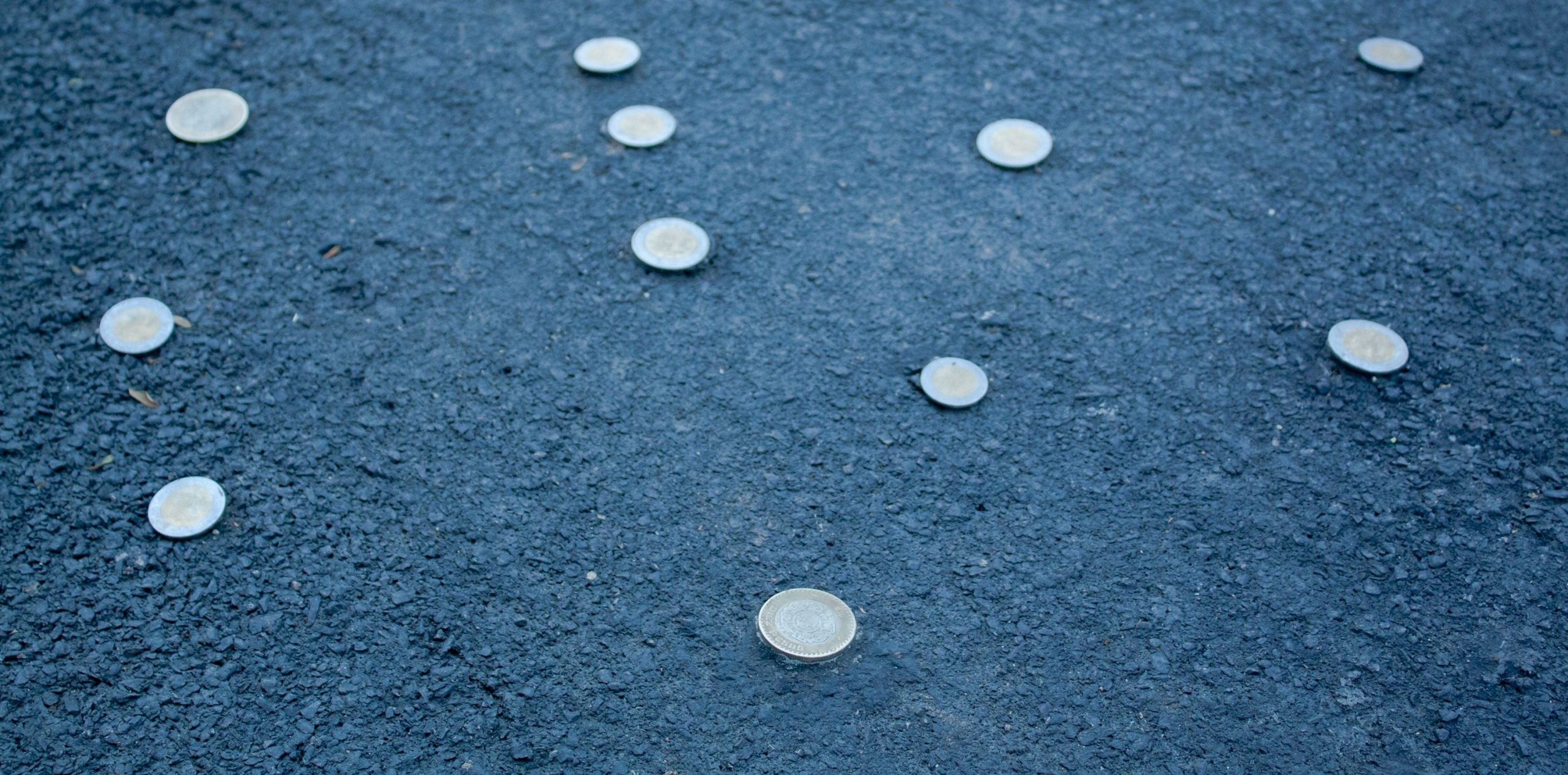 A close shot of coins screwed into the ground.