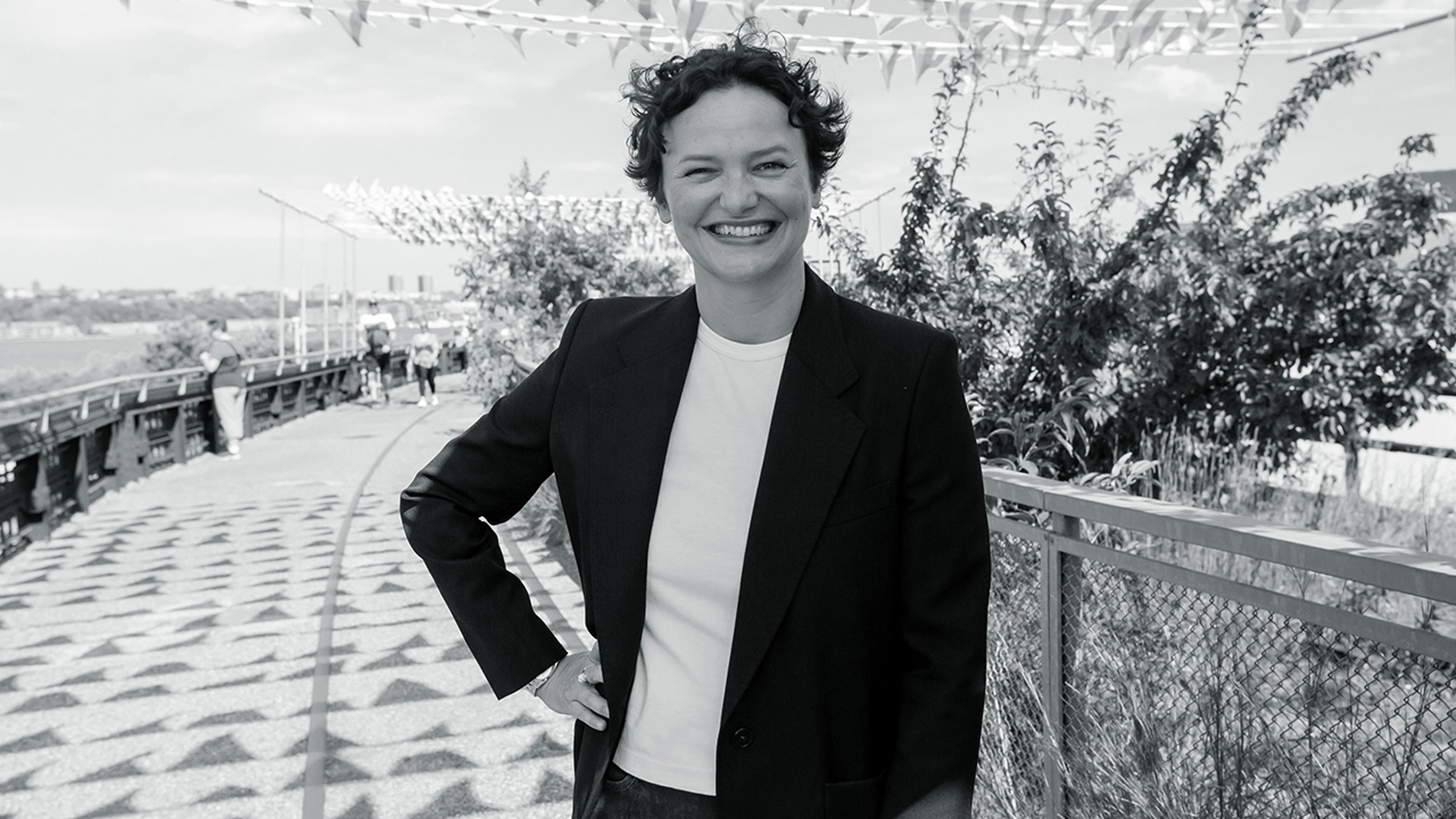 Black and white photograph of the Artistic Director of the 59th Venice Biennale Cecilia Alemani smiling at the camera