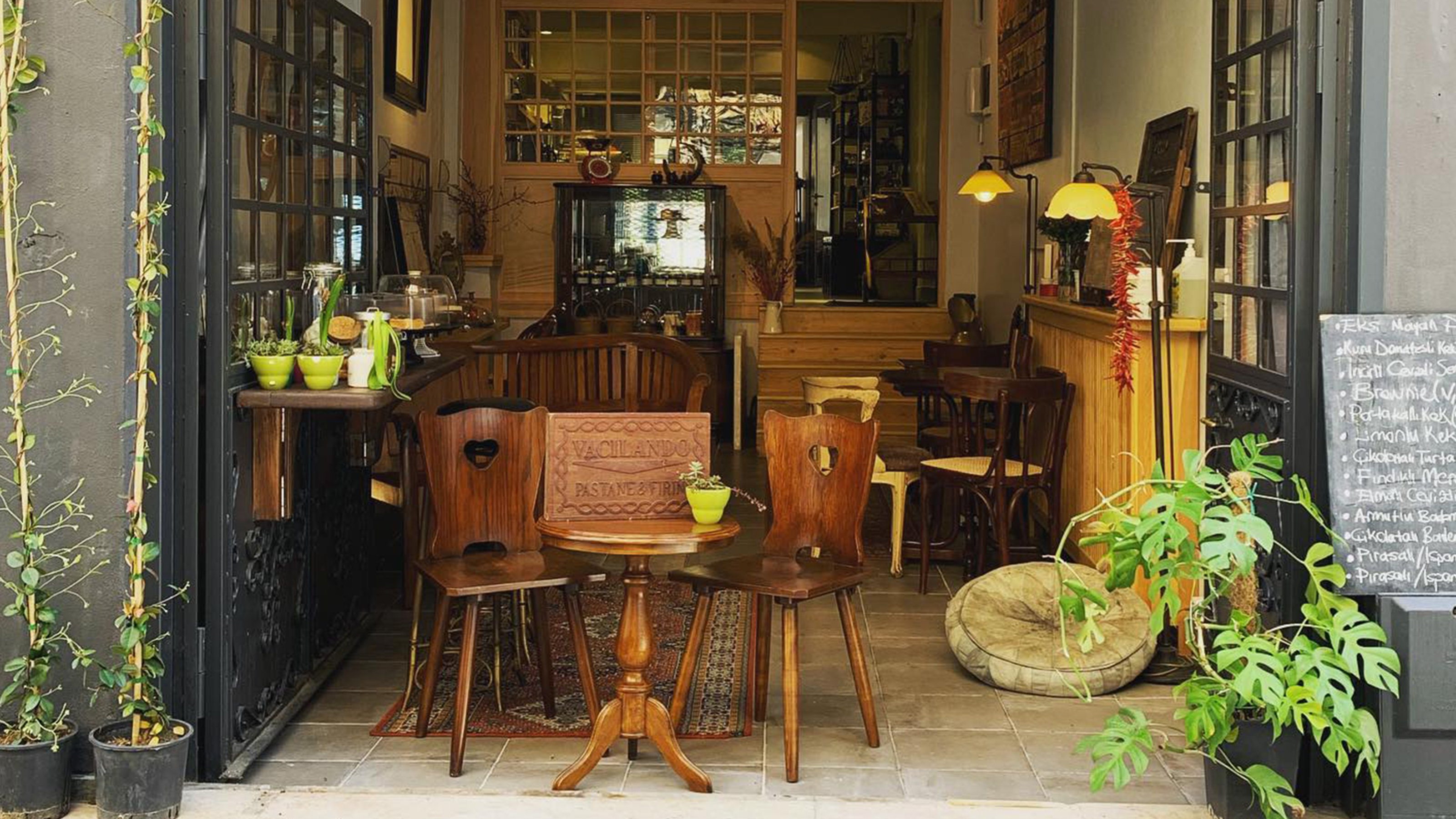 Interior view of the cafe with brown, wood and green plants in its design.