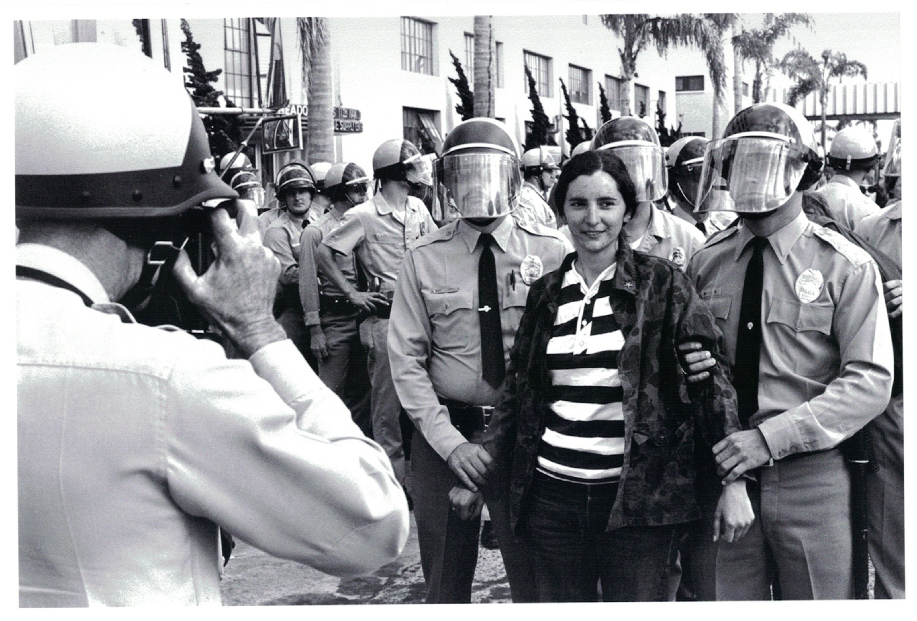A black and white photo of the police arresting a female