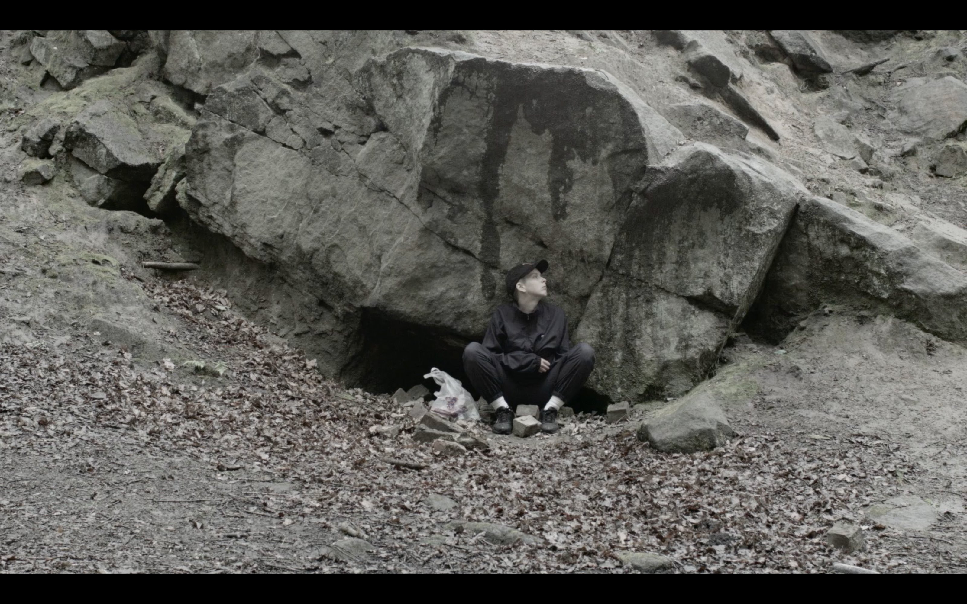 Roy Claire Potter sitting in front of a big rock 