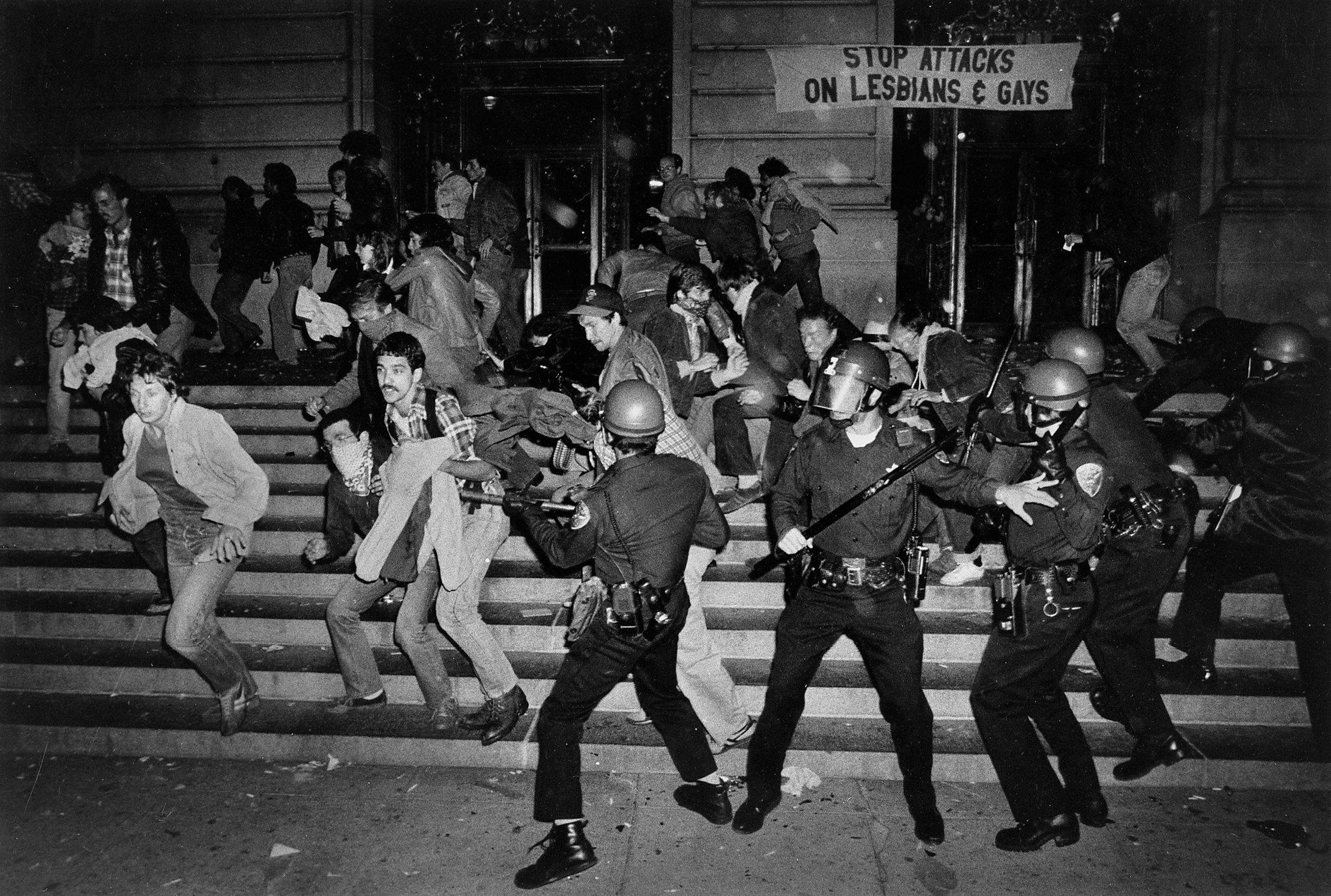 a black and white photo from an lgbtq riot with cops and protesters