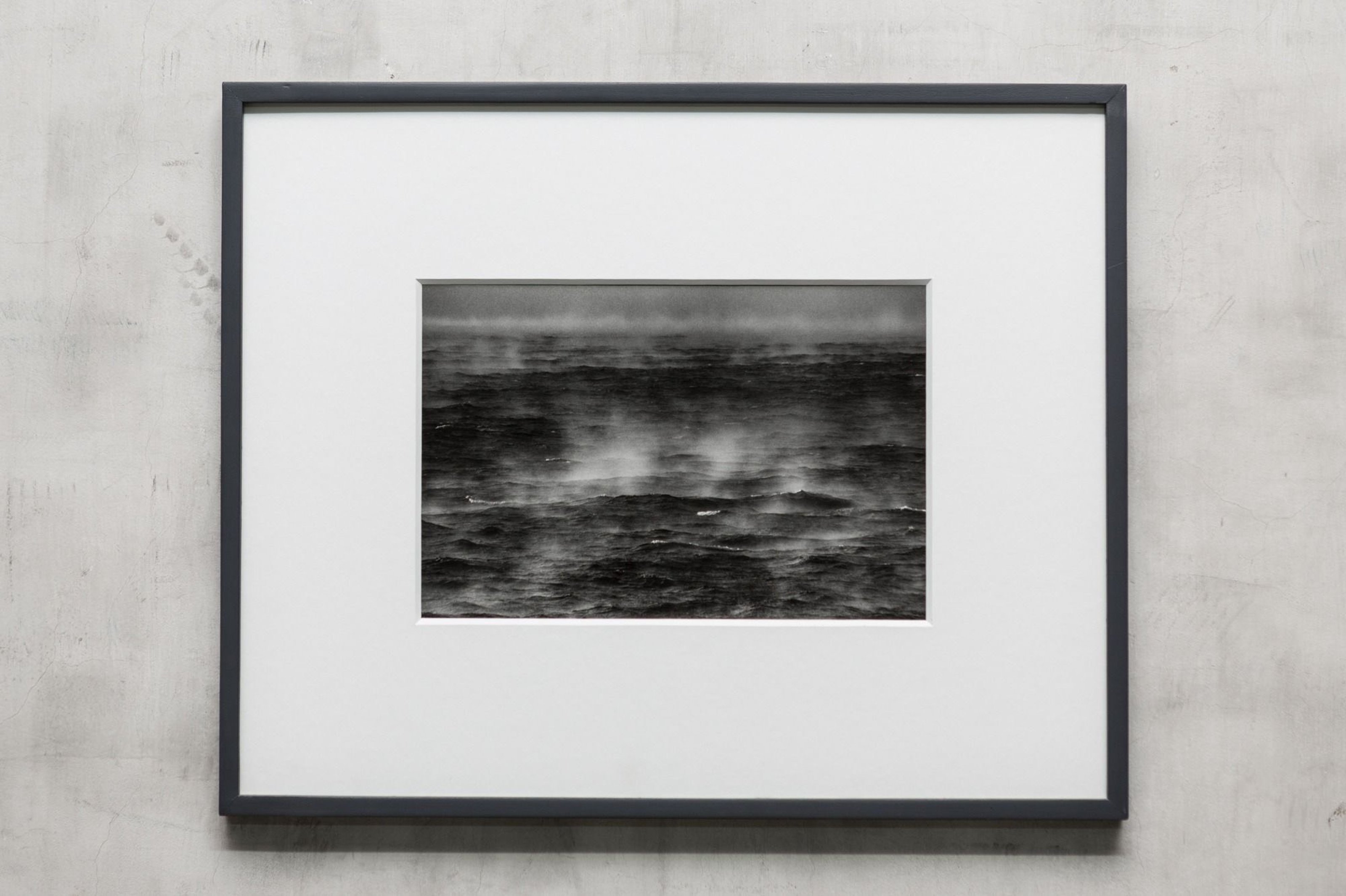 Framed black and white photograph of the sea and sky at storm