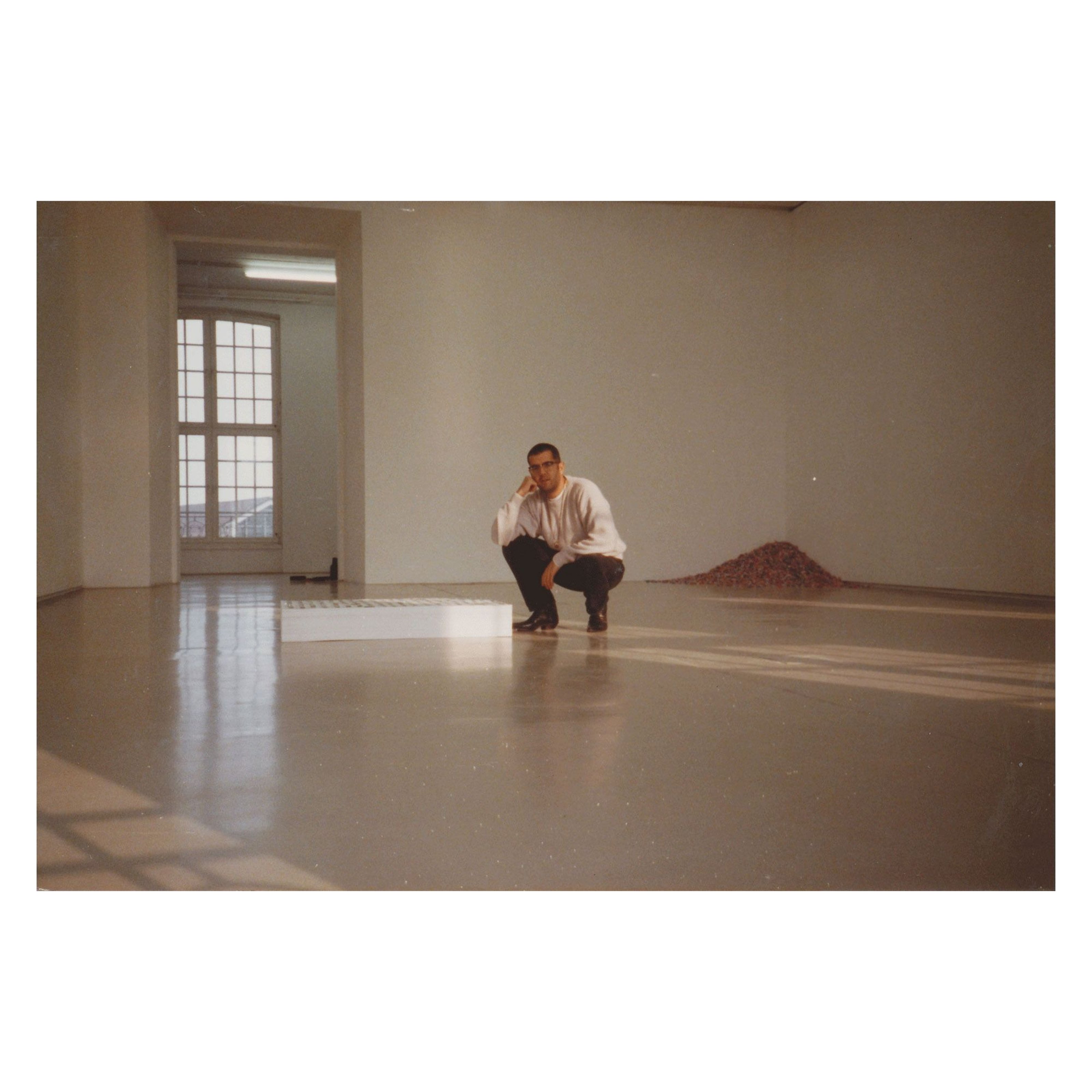 Felix Gonzalez-Torres squatting in the gallery space