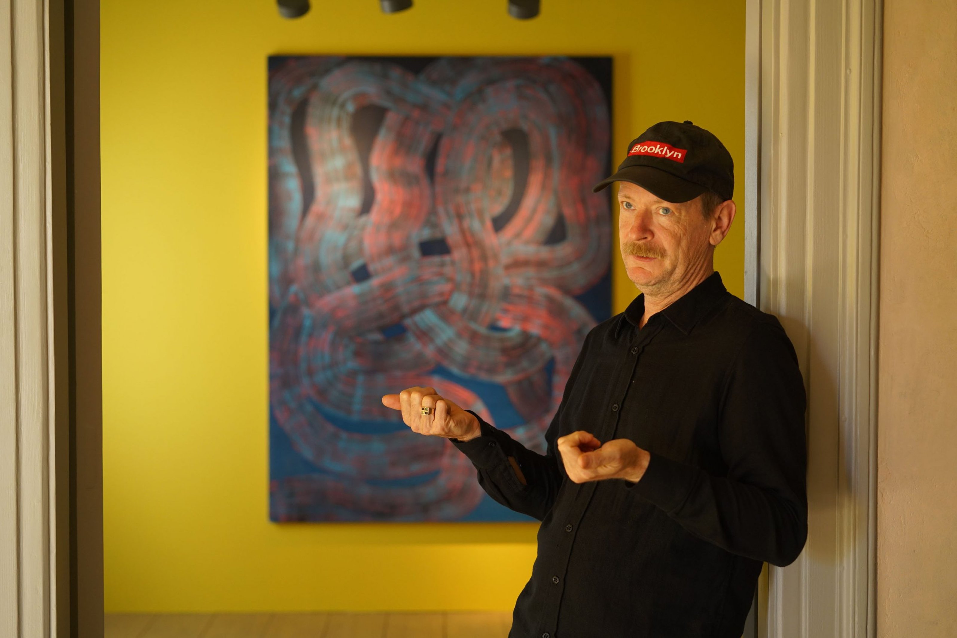 Photo of Robert Janitz in front of his painting