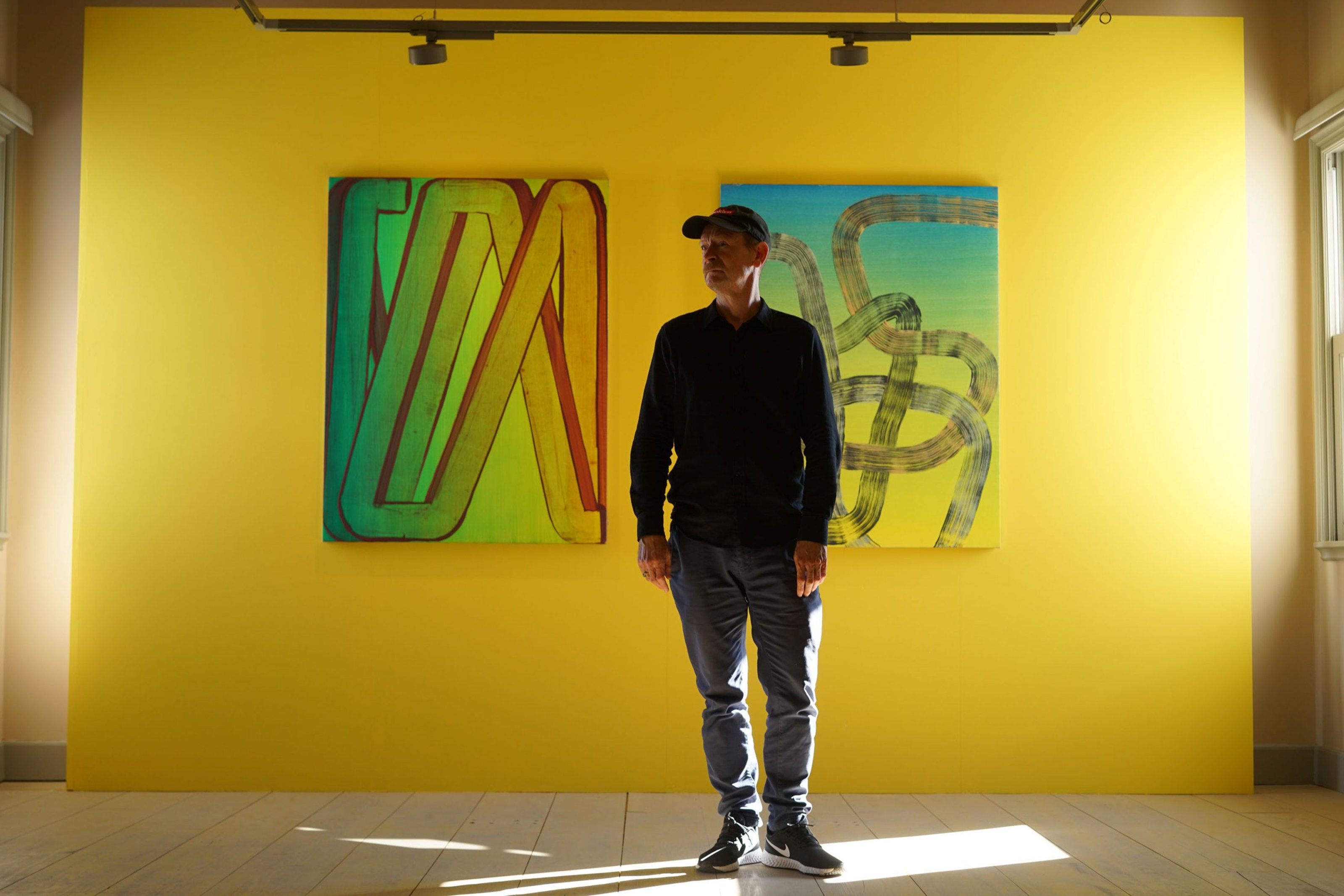 Photo of Robert Janitz in front of his abstract painting