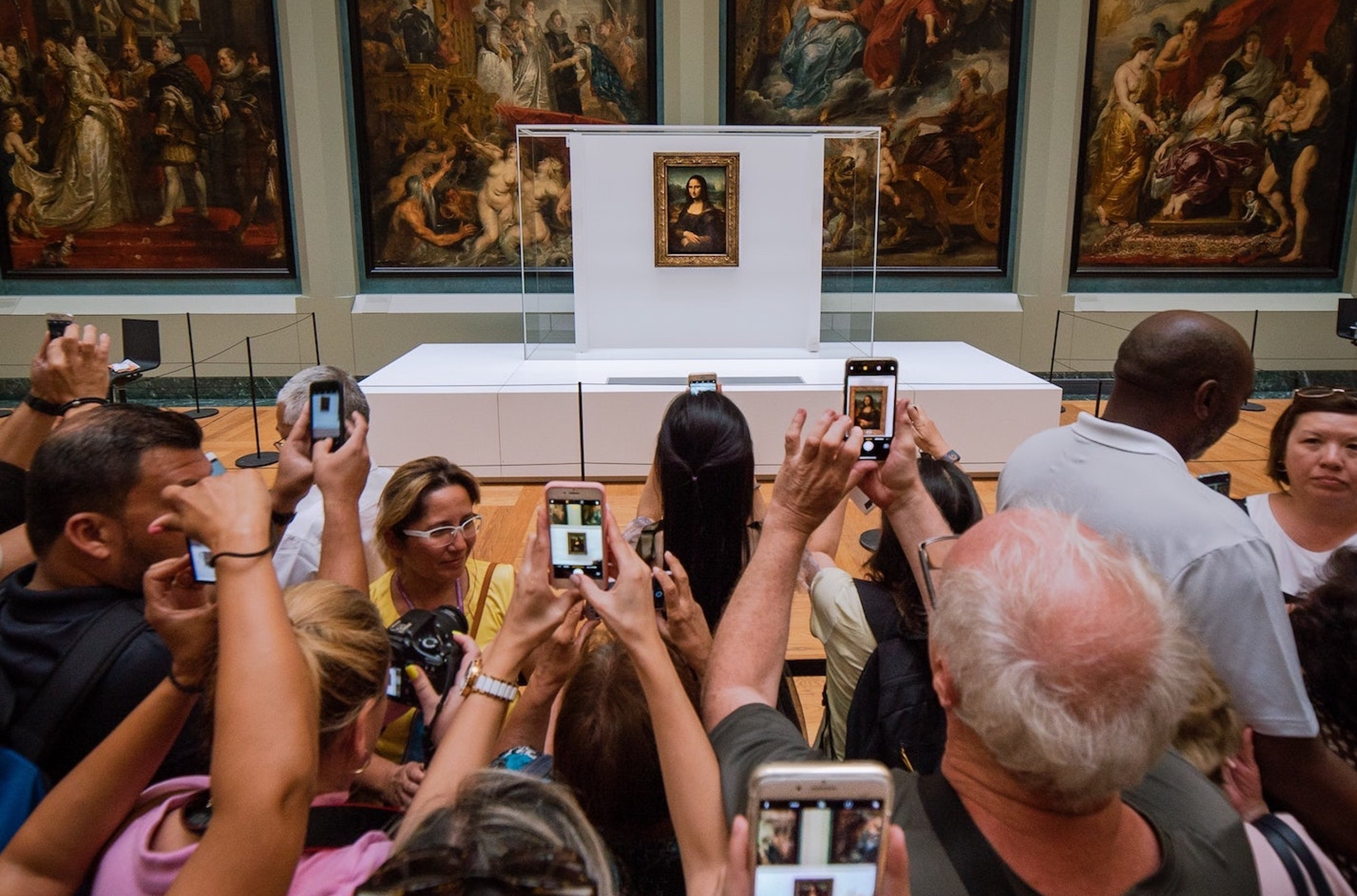 People taking photo of a painting inside the Louvre museum