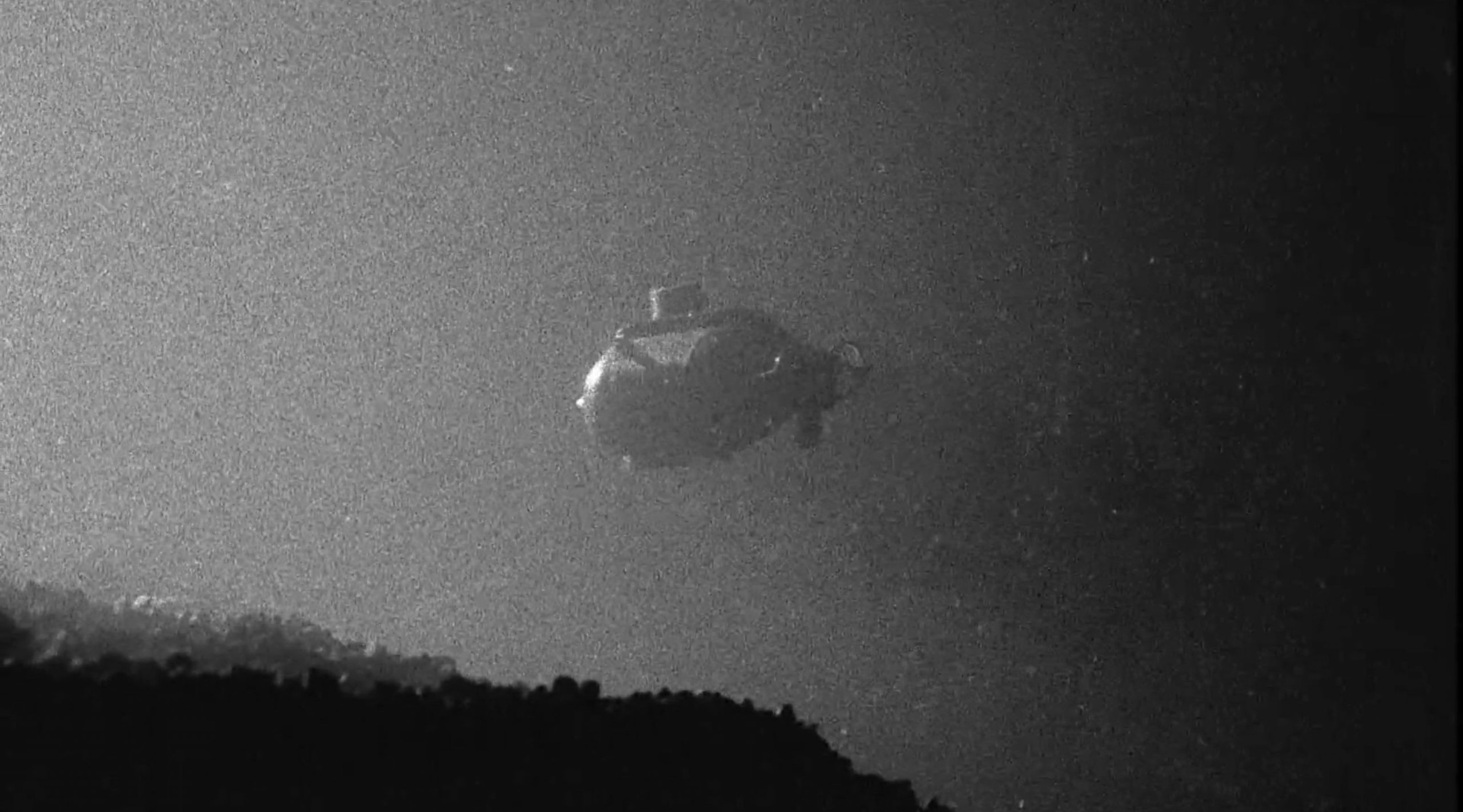 Film granulada que muestra un pequeño submarino en el agua