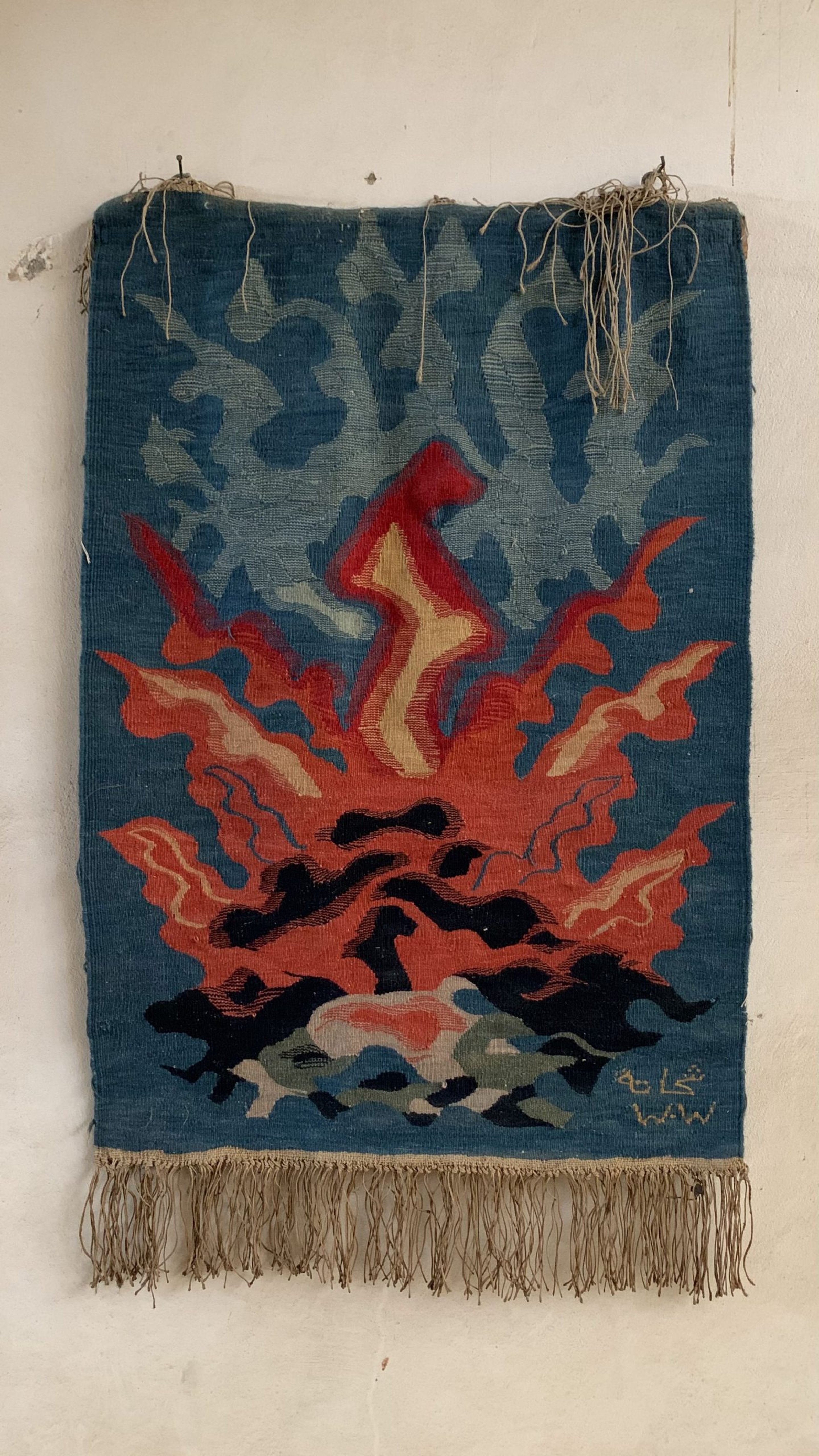 Photo of a tapestry with dark blue and red colors