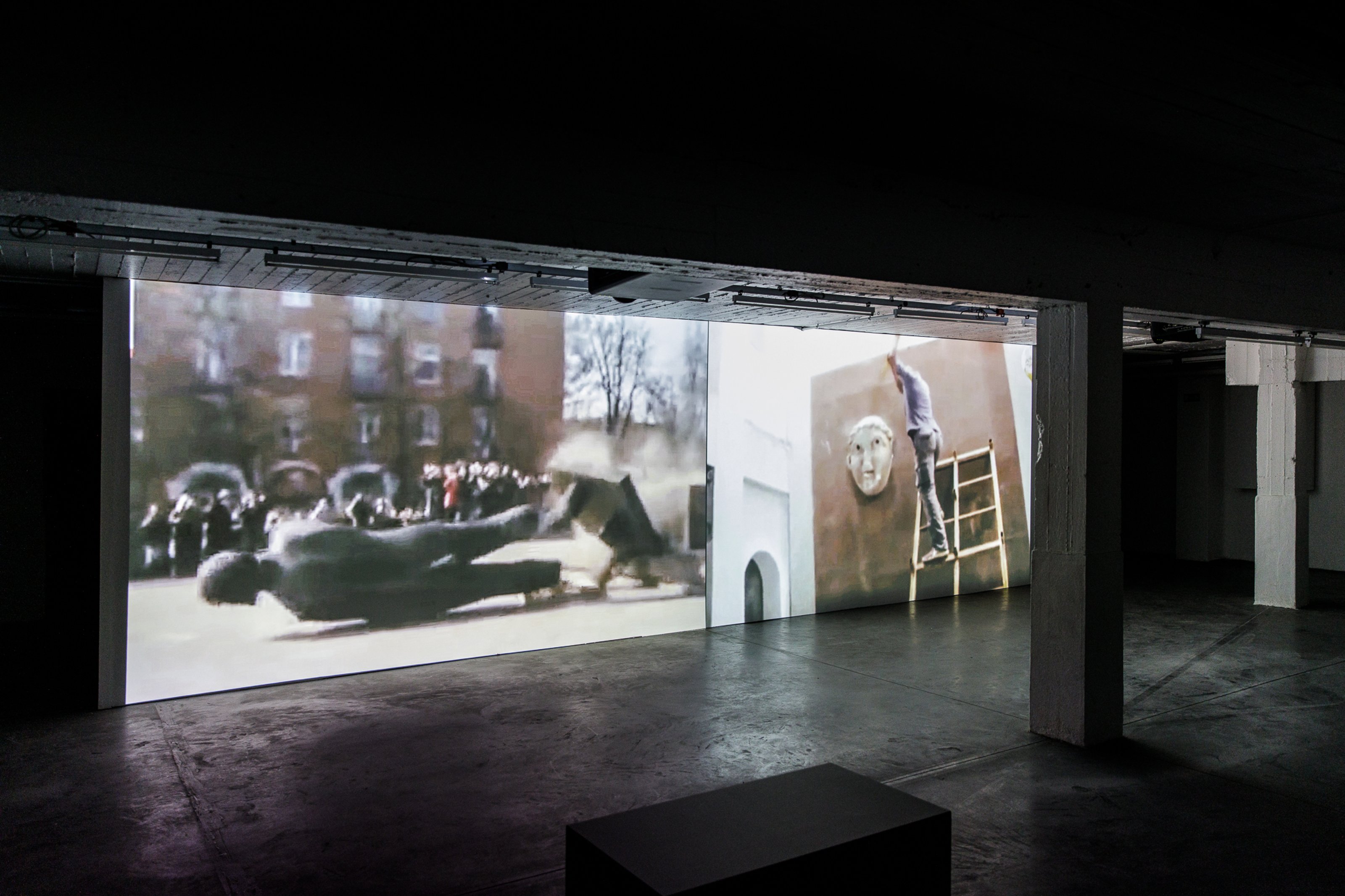 View of a two-channel video installation from Proposal for Non-Aligned Monuments, Free Movement exhibition. A destroyed monument on channel one. A person destroying a monument on channel two.